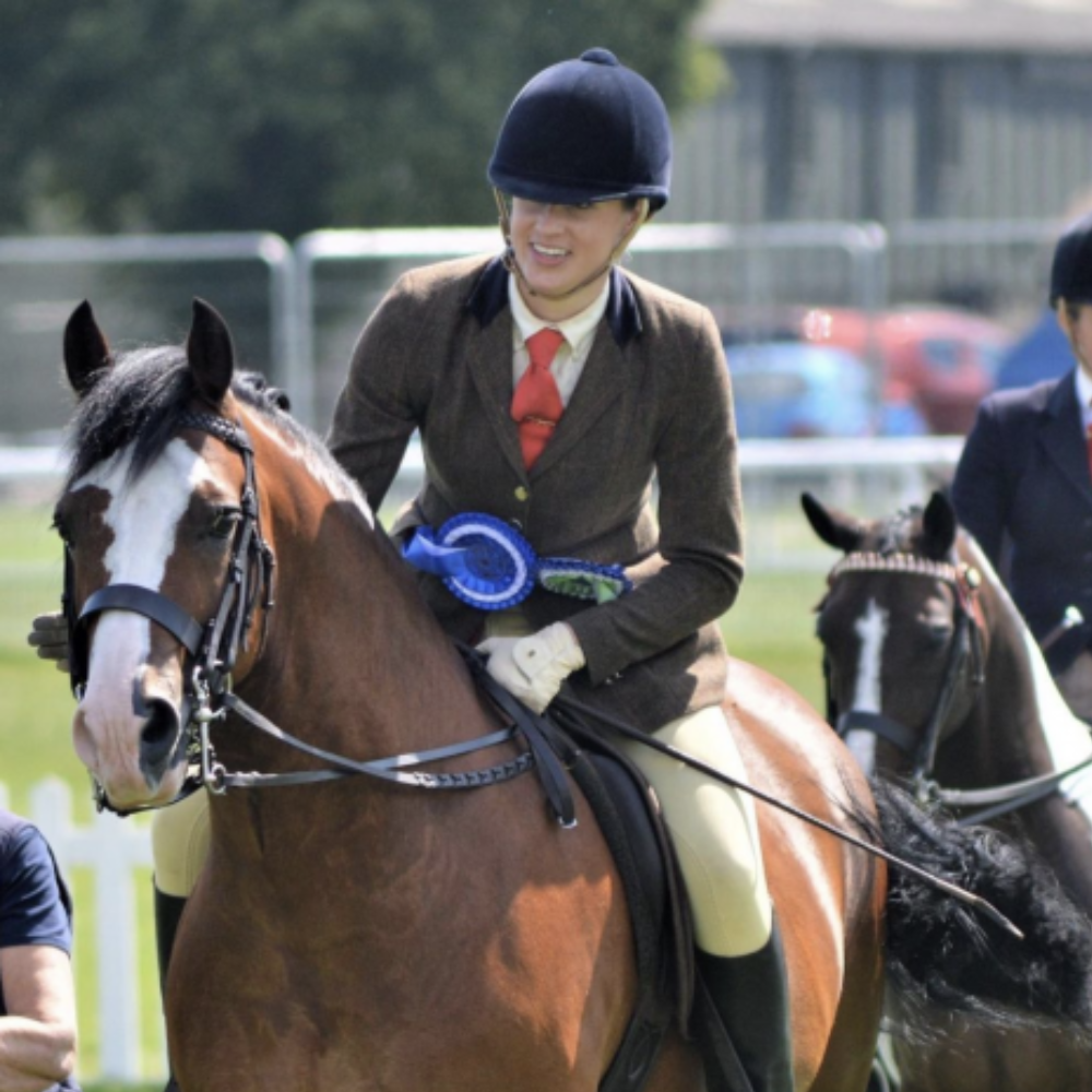 Alex Robinson riding a horse at a show