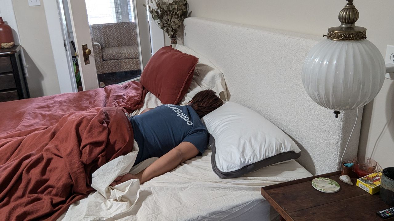Reviewer Alex sleeping on the Sleep Number NaturalFit Ultimate Pillow