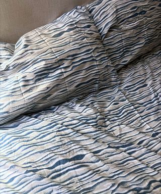 A blue and gray patterned duvet cover on a bed