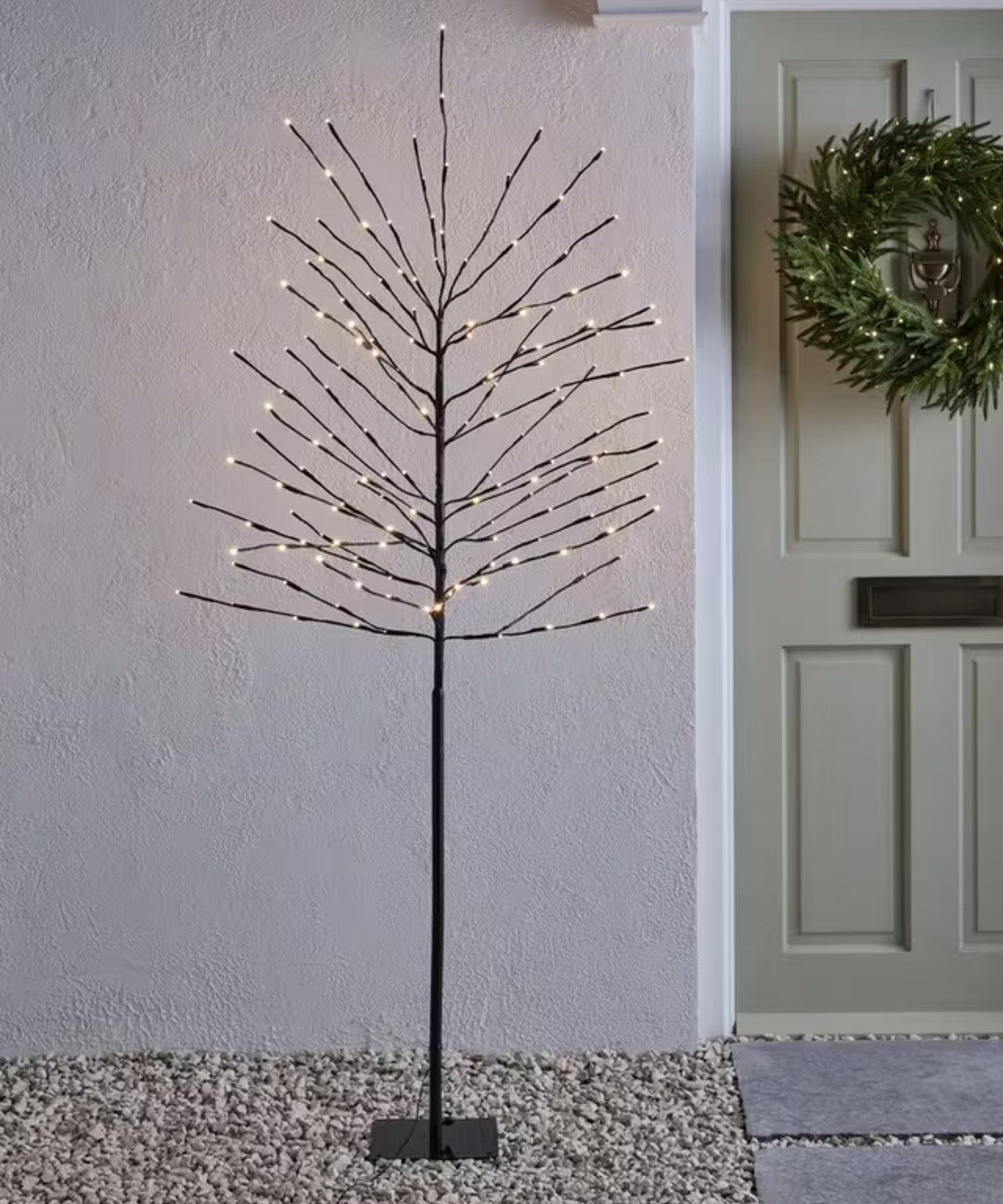 Lumineo Pre-Lit Twig Tree, 6ft, Black outside a sage green front door decorated with a Christmas wreath