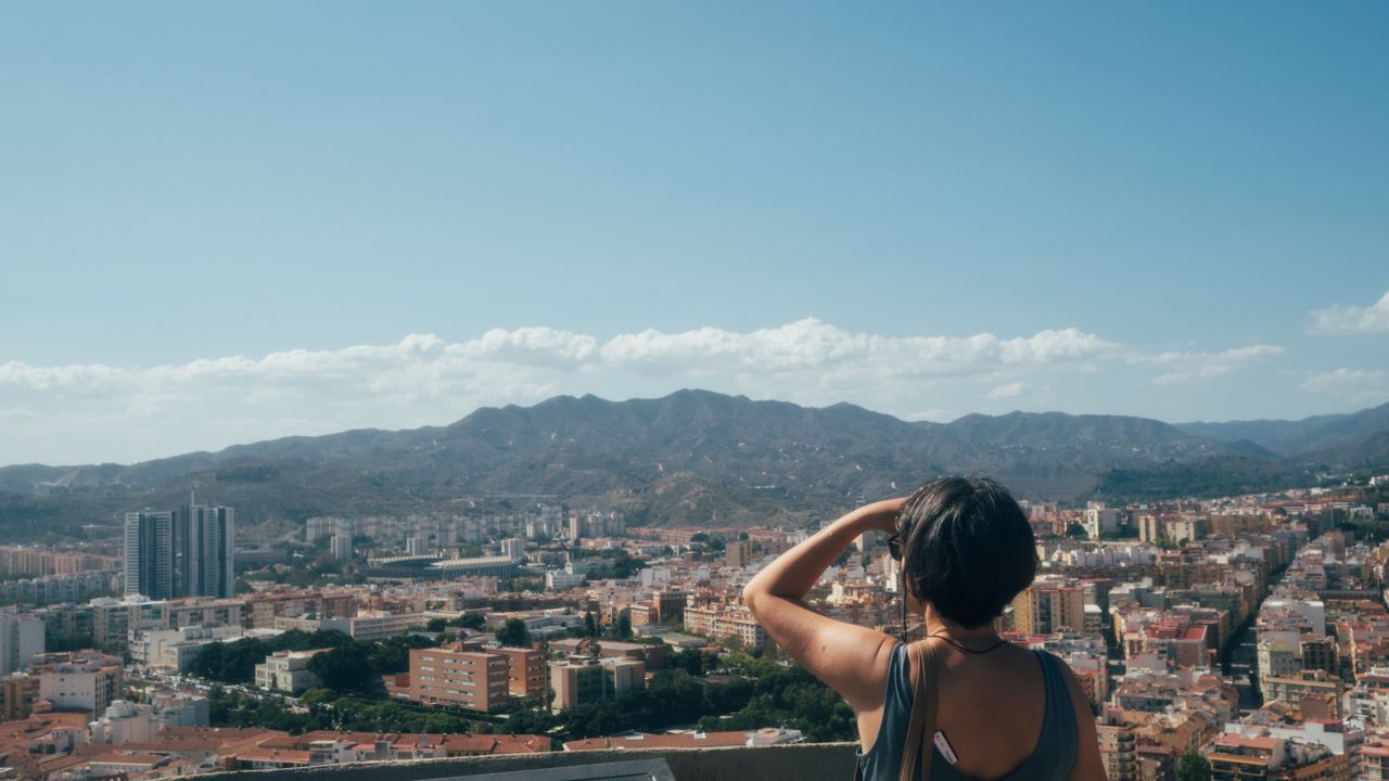 An image of a woman looking out over the city of Malaga in Spain, Olympus EM-5 Mark II sample images