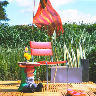 garden with red chair and gnomes