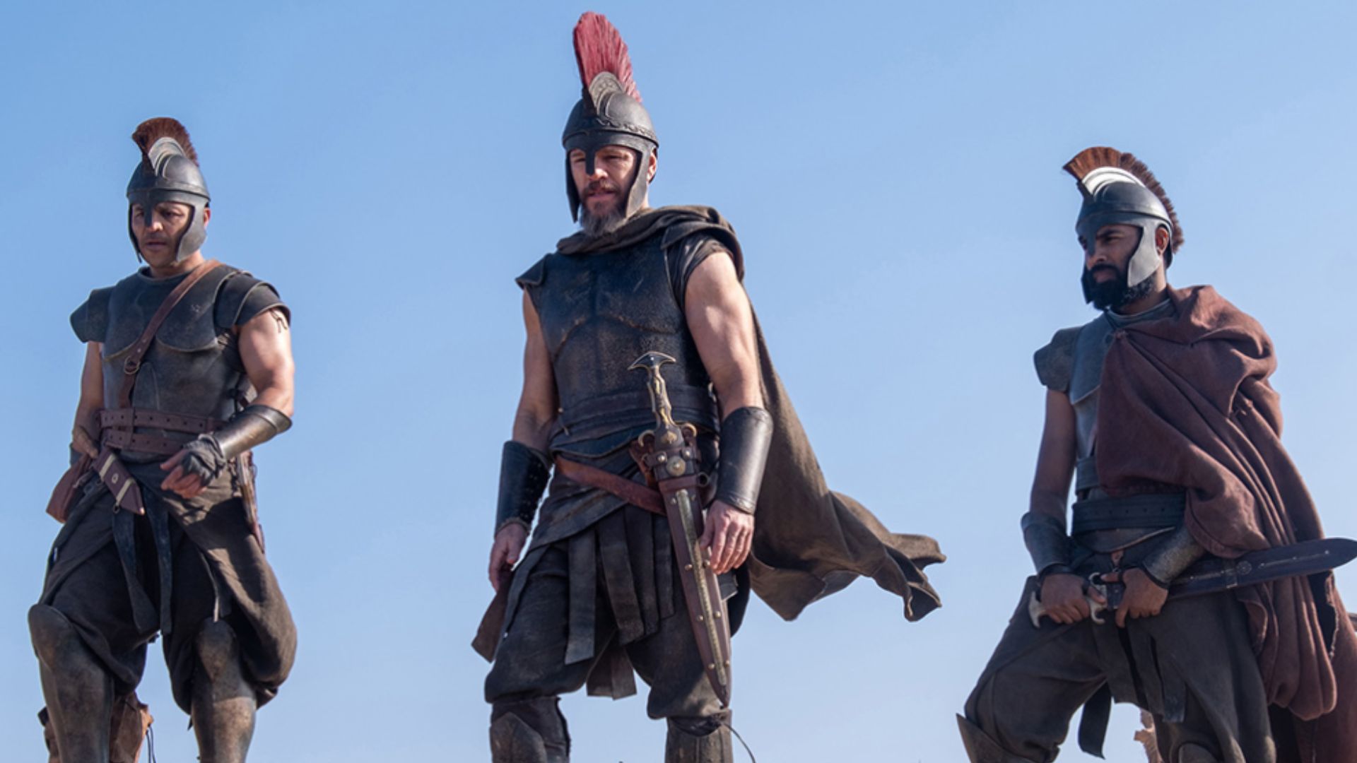 Three Greek soldiers stand in a row