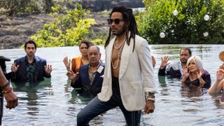 Lenny Kravitz as Sean in Shotgun Wedding wearing a white jacket with a bare chest underneeth and standing in a swimming pool