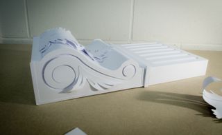 A Relief Art made out of constructed from paper stock. It forms crisp lines and angles, with flowing curves as well.