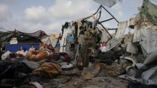 Displaced Palestinians inspect their tents destroyed by Israel's bombardment, adjunct to an UNRWA facility west of Rafah city, Gaza Strip