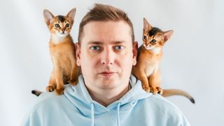 Man with 2 Abyssinian cats on his shoulders