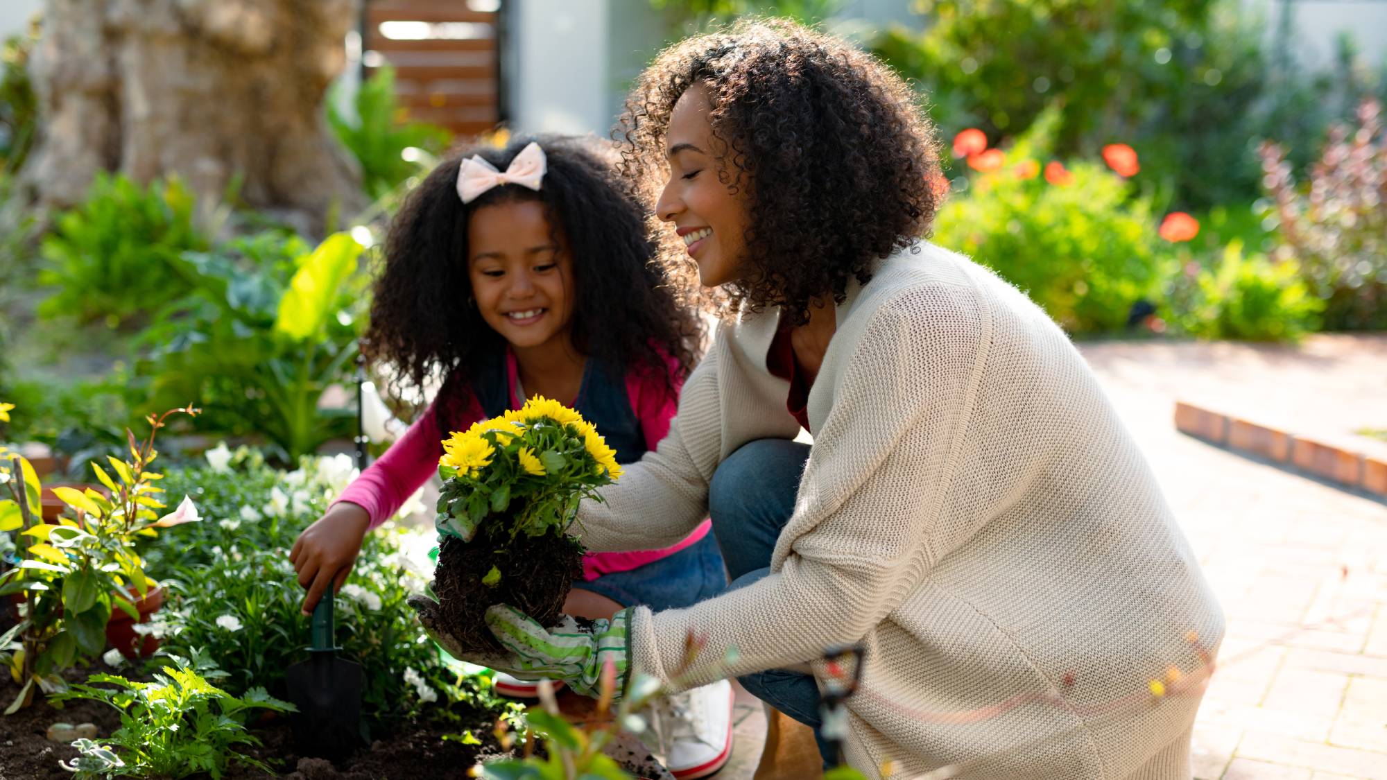Woman and daughter planting garden