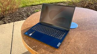 Image of the Lenovo IdeaPad Slim 3i 15 (Gen 9) in "Abyss Blue" on a table outside.