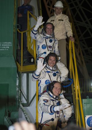 American astronaut Mike Hopkins (center) and Russian cosmonauts Oleg Kotov (bottom) and Sergey Ryazanskiy wave just before boarding their Soyuz TMA-10M spacecraft during a launch to the International Space Station on Thursday, Sept. 26 from Baikonur Cosm