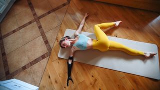 Woman lying on floor performing back twist