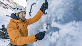what is ice climbing: climber screws in ice screw