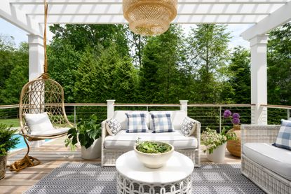 white patio furniture on a deck with pergola