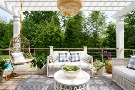 white patio furniture on a deck with pergola