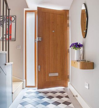 entrance of room with white wall and wooden door