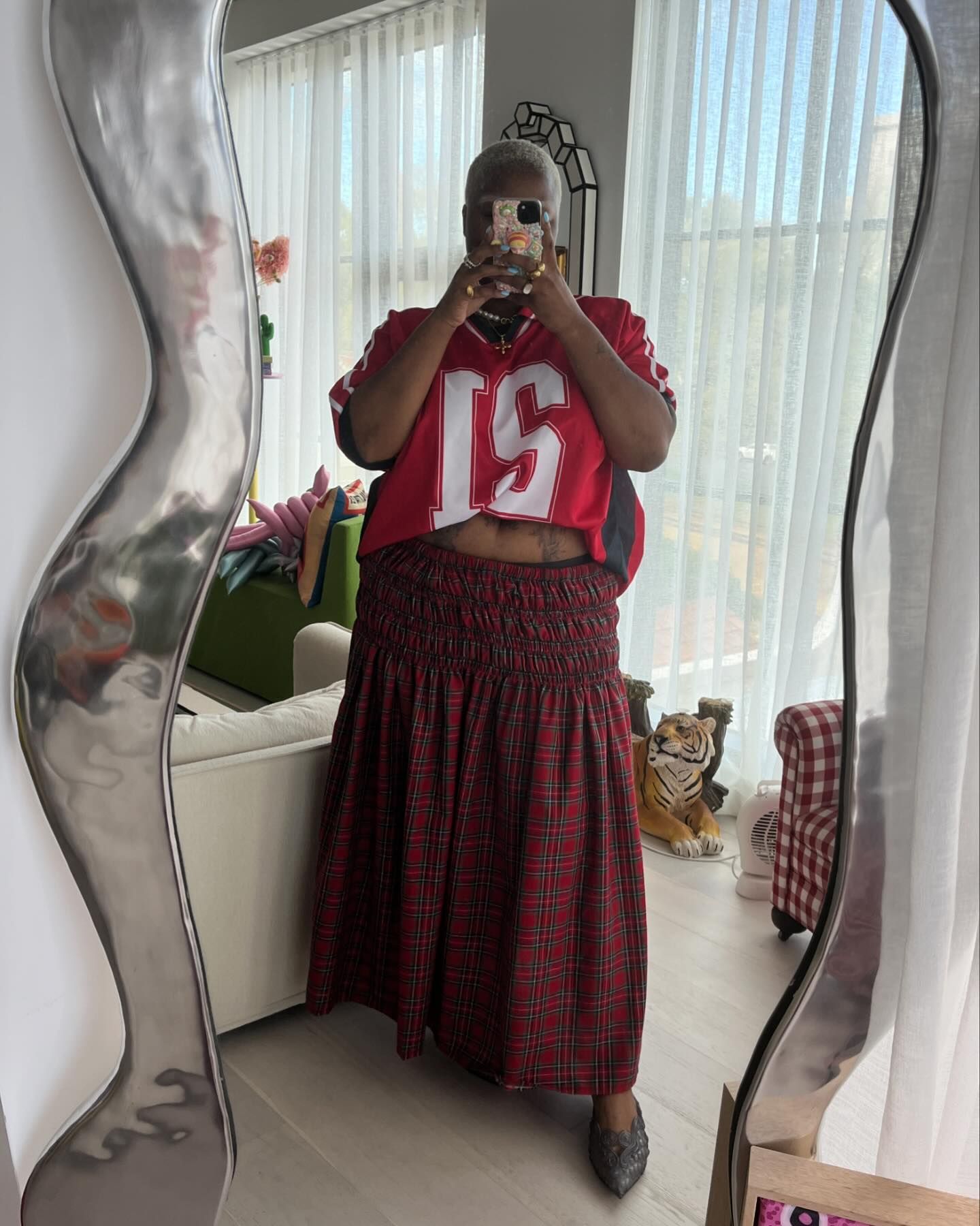 Flex wears jersey and plaid skirt and black pointed flats