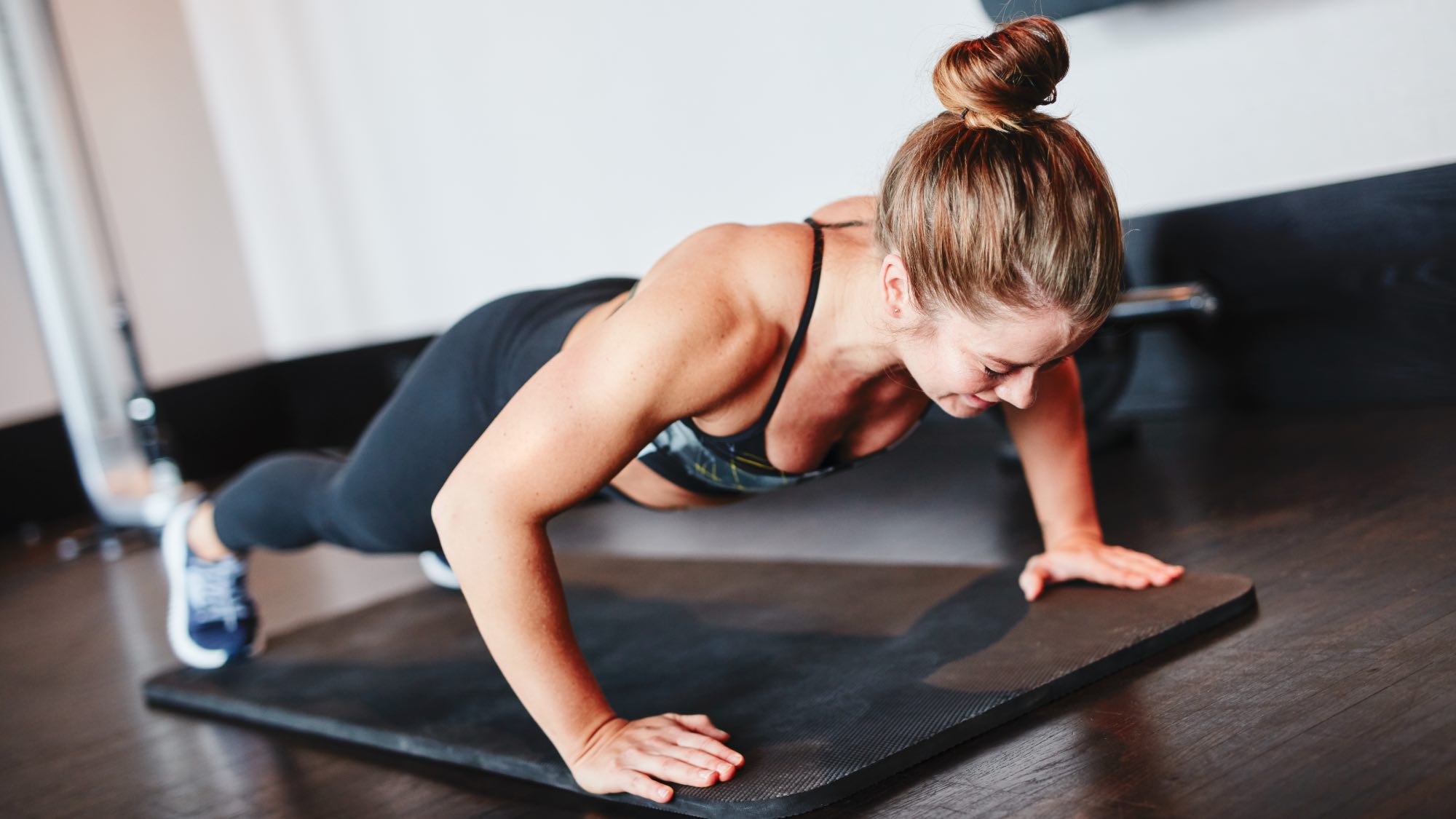 woman doing push ups in gym
