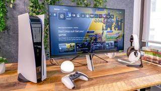 Sony Inzone M9 gaming monitor sitting on desk next to PS5 with display on