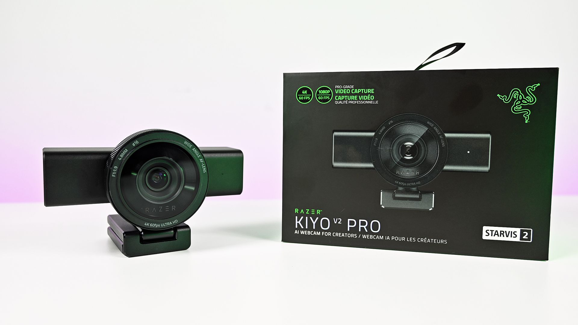 Razer Kiyo V2 Pro webcam on its monitor mount next to its black retail box under bright white studio lighting