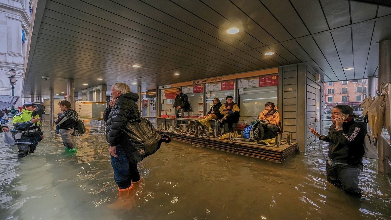 VENICE, ITALY - OCTOBER 29: Tourists await for the reopening of the Vaporetti service, after the authorities temporarily suspended it due to flooding caused by a high tide on October 29, 2018