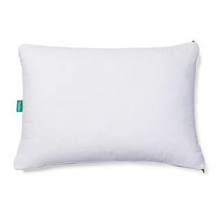 A white pillow with a teal small label on the left hand side