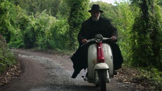 Father Gabriele (Russell Crowe) riding on a scooter in a scene from "The Pope's Exorcist"