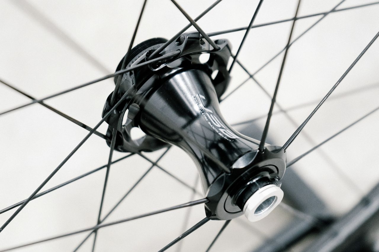 An aero road wheel stands against a white wall