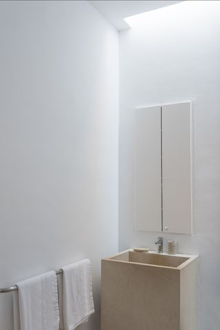 minimalist bathroom with concrete sink and white walls