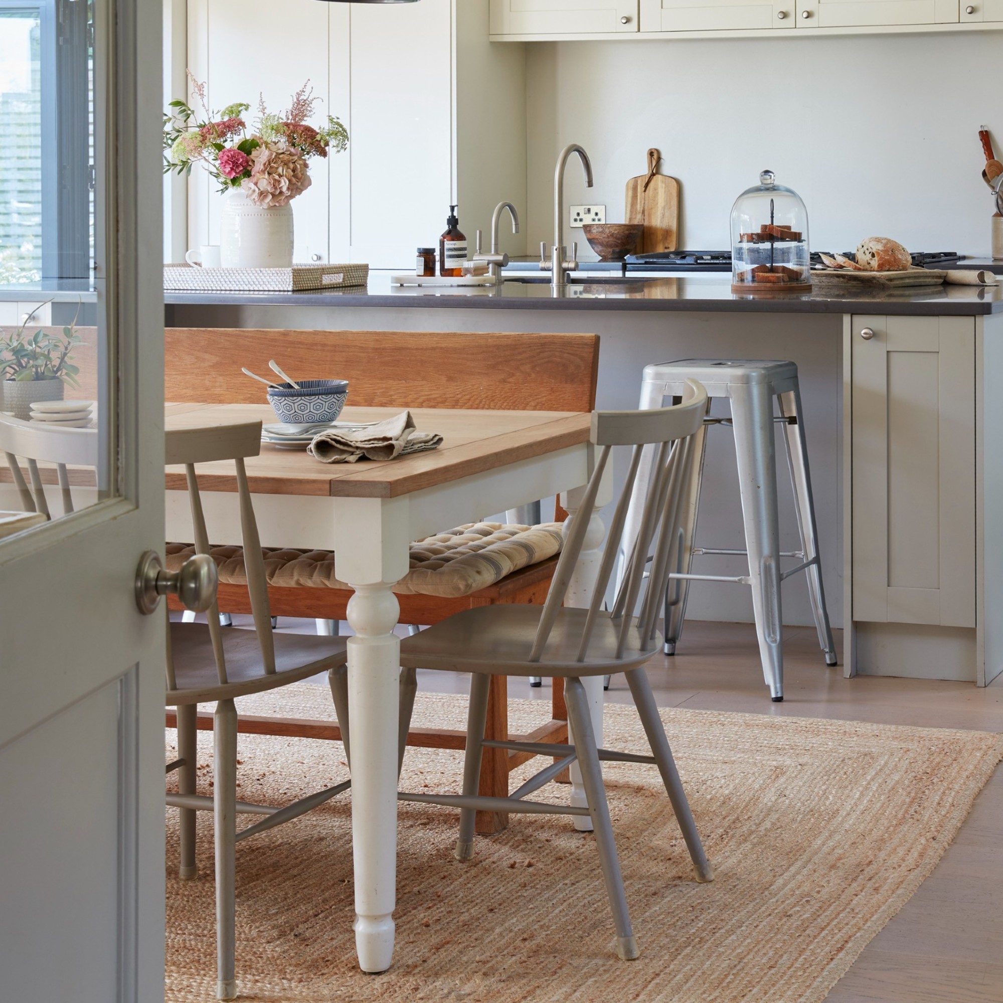 Neutral kitchen diner with jute rug beneath dining table