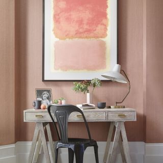 room with pink wall and desk and chair and painting frame and white lamp