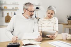 Portrait of a senior couple managing their finances together at home.