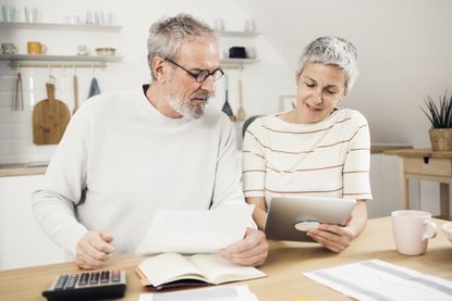 Portrait of a senior couple managing their finances together at home.