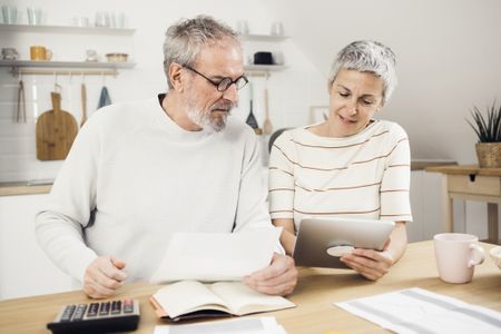 Portrait of a senior couple managing their finances together at home.