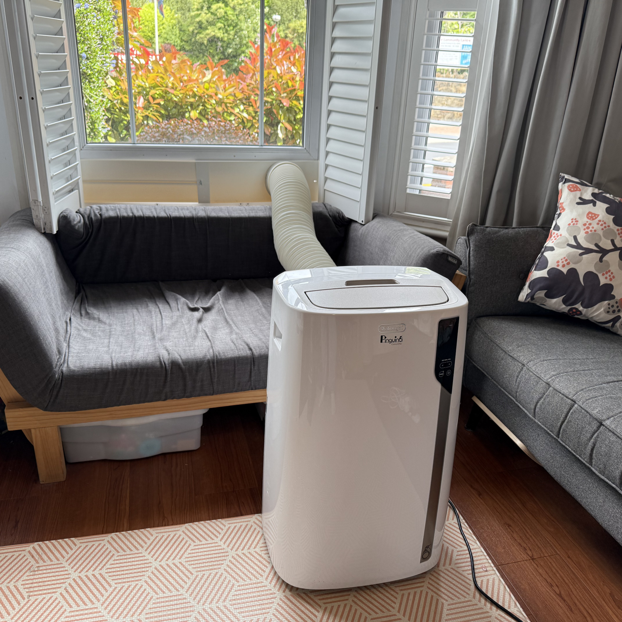 delonghi pinguino care4me portable air conditioner installed in a living room