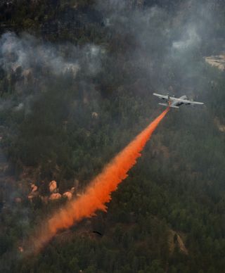 A U.S. Air Force C-130 Hercules aircraft uses a modular airborne firefighting system to spread fire retardant on the Waldo Canyon wildfire in Colorado Springs, Colo., on June 28, 2012. The Waldo Canyon fire, which started June 23, has burned several hundred homes and forced large-scale evacuations in Colorado Springs.