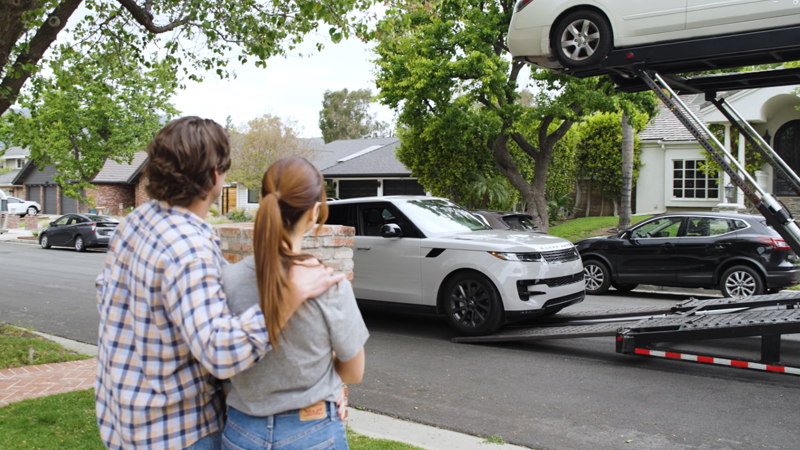 A couple watching their car be taken away by RoadRunner.