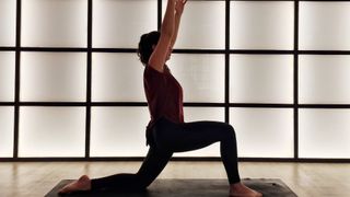 Woman performing a low lunge with arms overhead