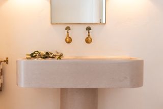 A curved bathroom sink in pale pink