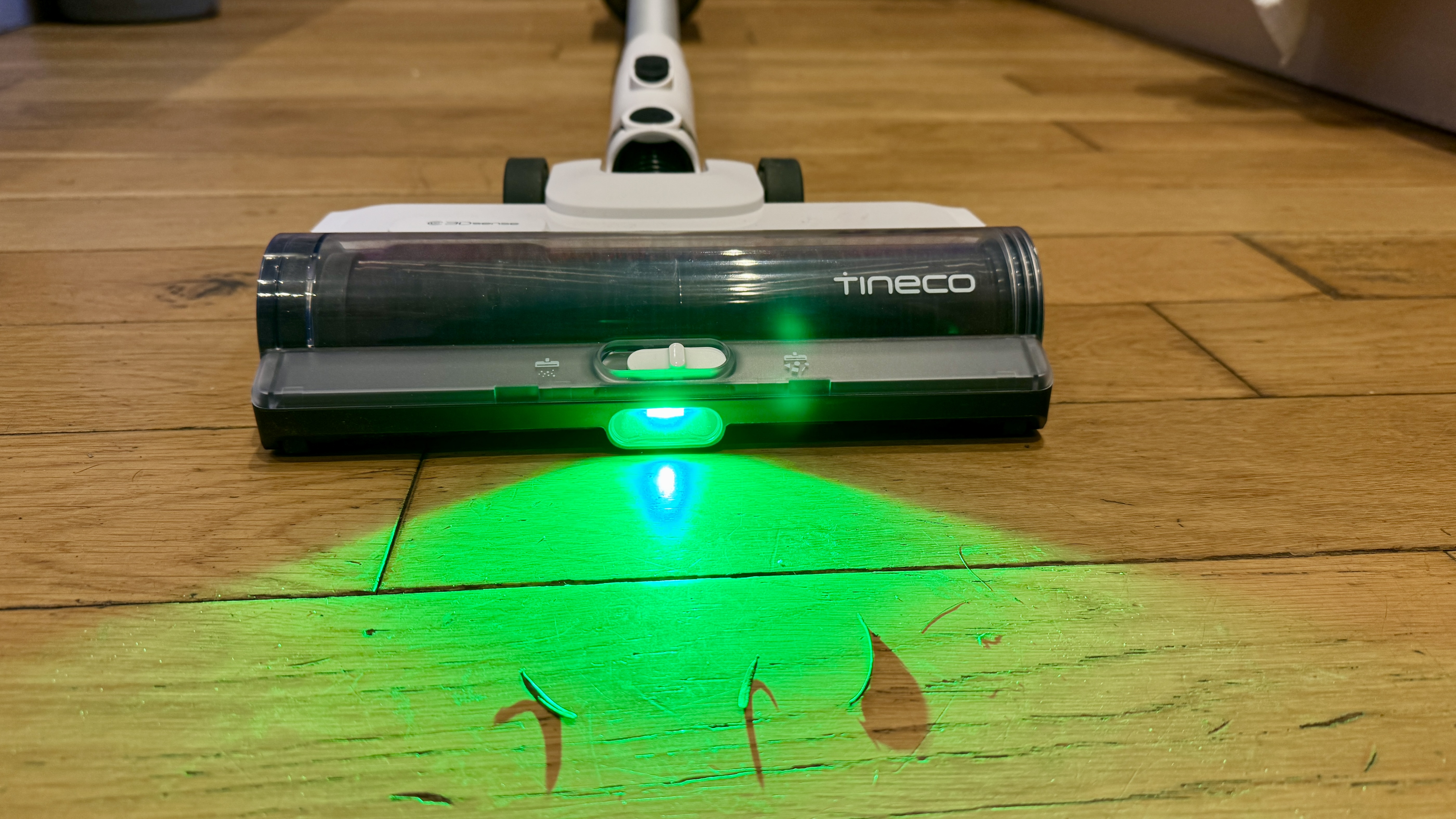 Tineco Pure One A50S cordless stick vacuum floorhead glowing green to highlight dust