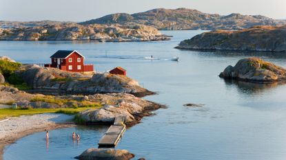 People swim in the water off the island of Tjorn in Sweden