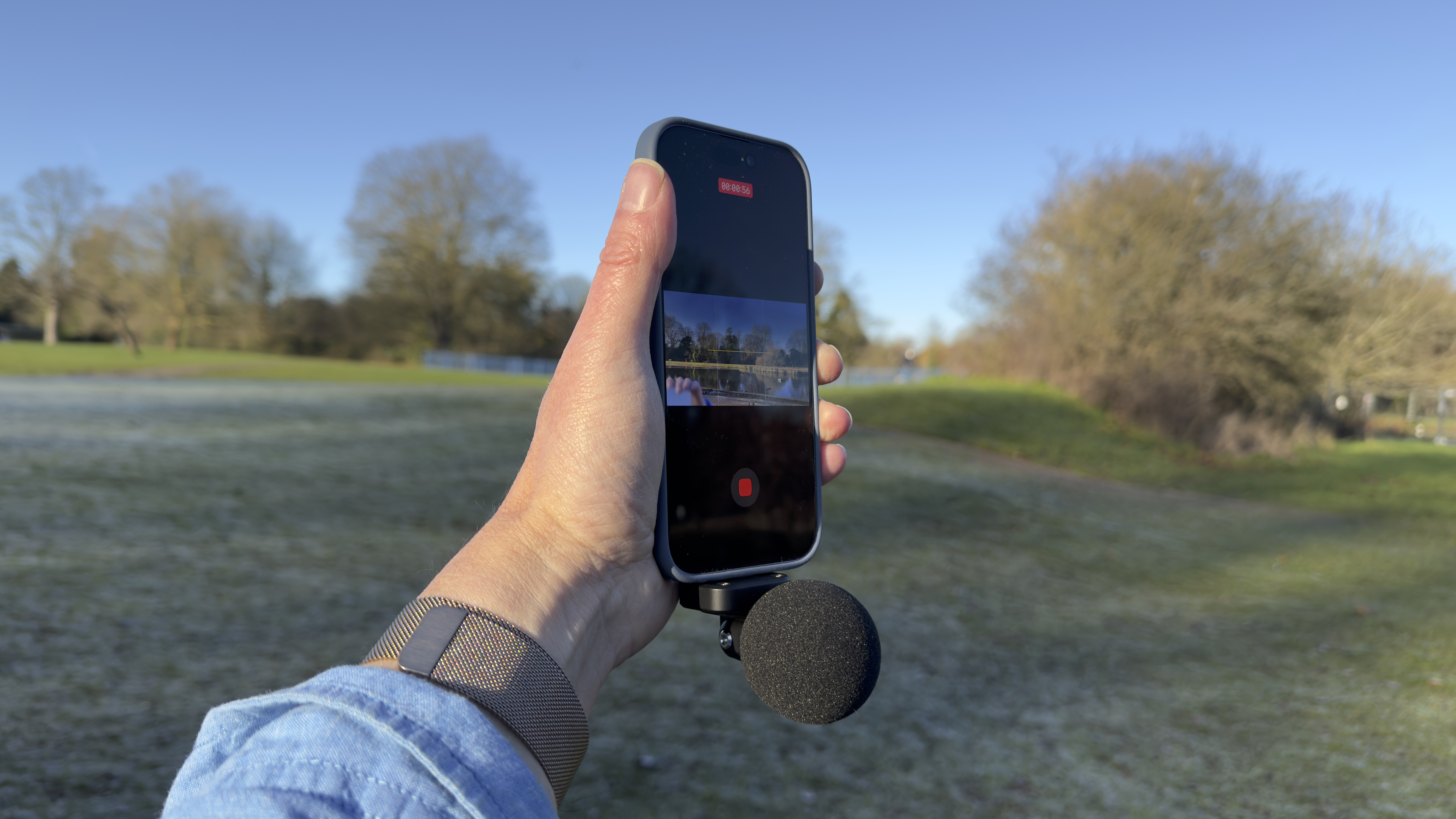 Shot of the MV88 attached to an iPhone 17. The mic is wearing a circular foam windshield