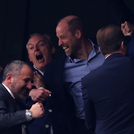 Prince William cheering with friends at an Aston Villa match