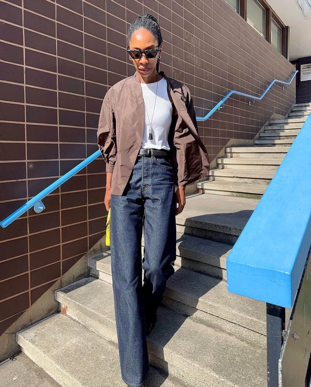 Woman wearing long, baggy jeans fall denim trend 2025.