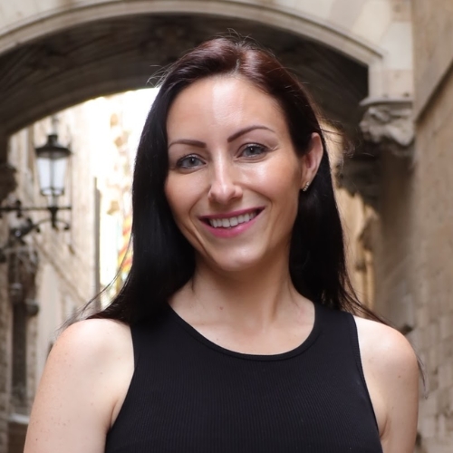 Picture of a woman in a black tank top standing outside.