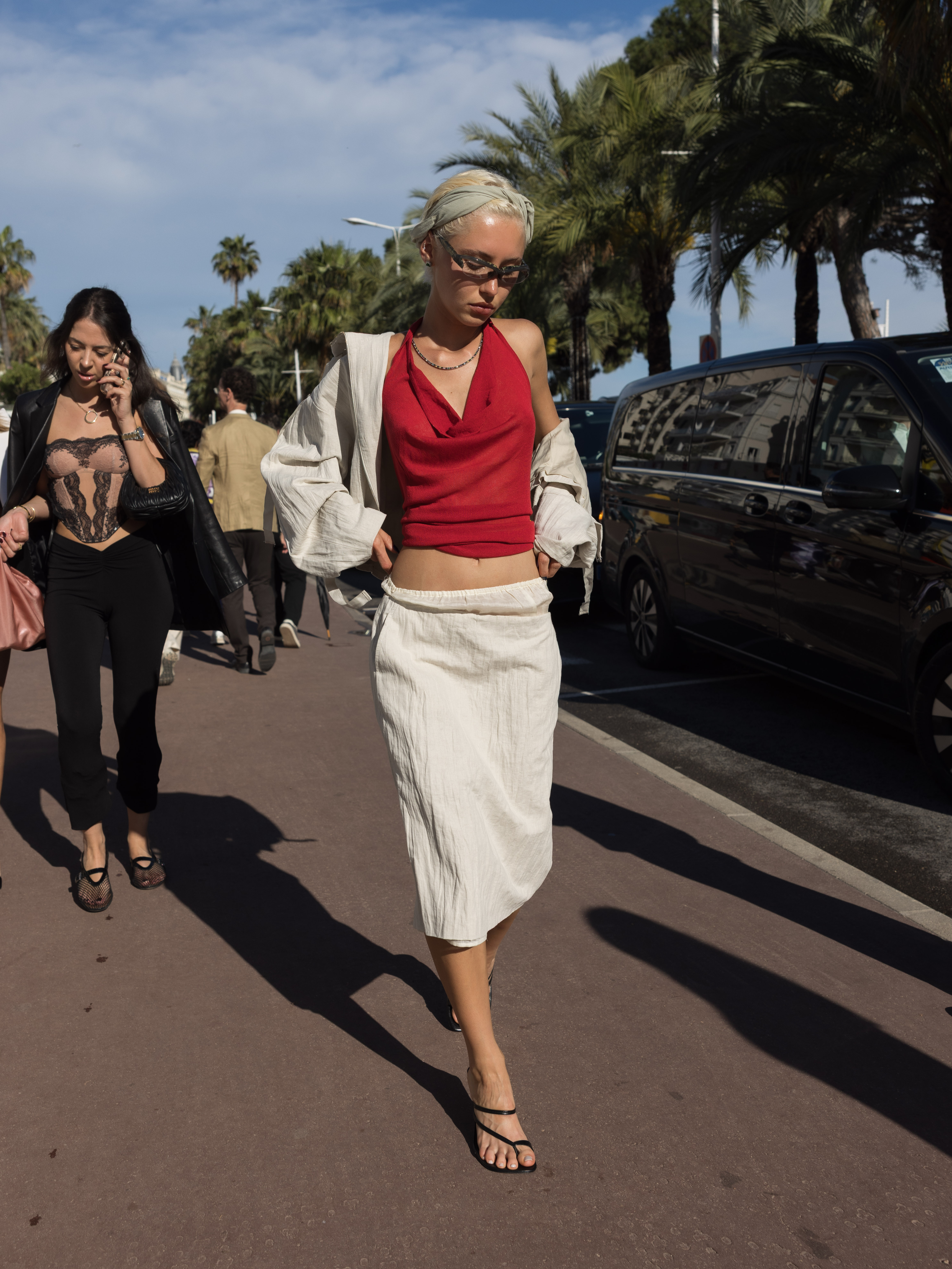 Iris Law wearing a red halter top with a white midi skirt.