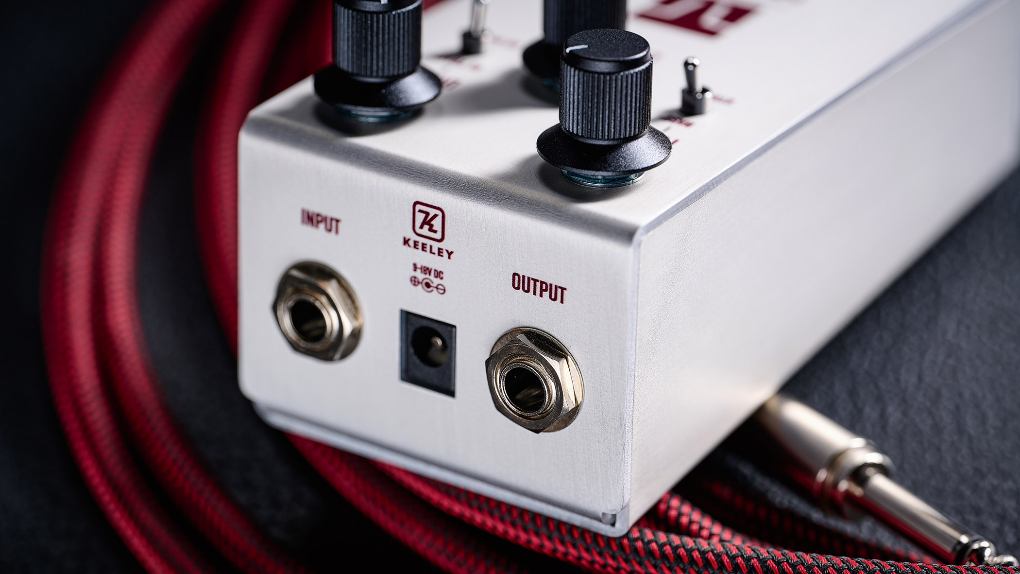 Keeley Electronics Manis: this ingenuous twist ont he K-style overdrive has three-knobs, a couple of mode switches, a tidy white finish and is photographed here against an amp with a red guitar cable.