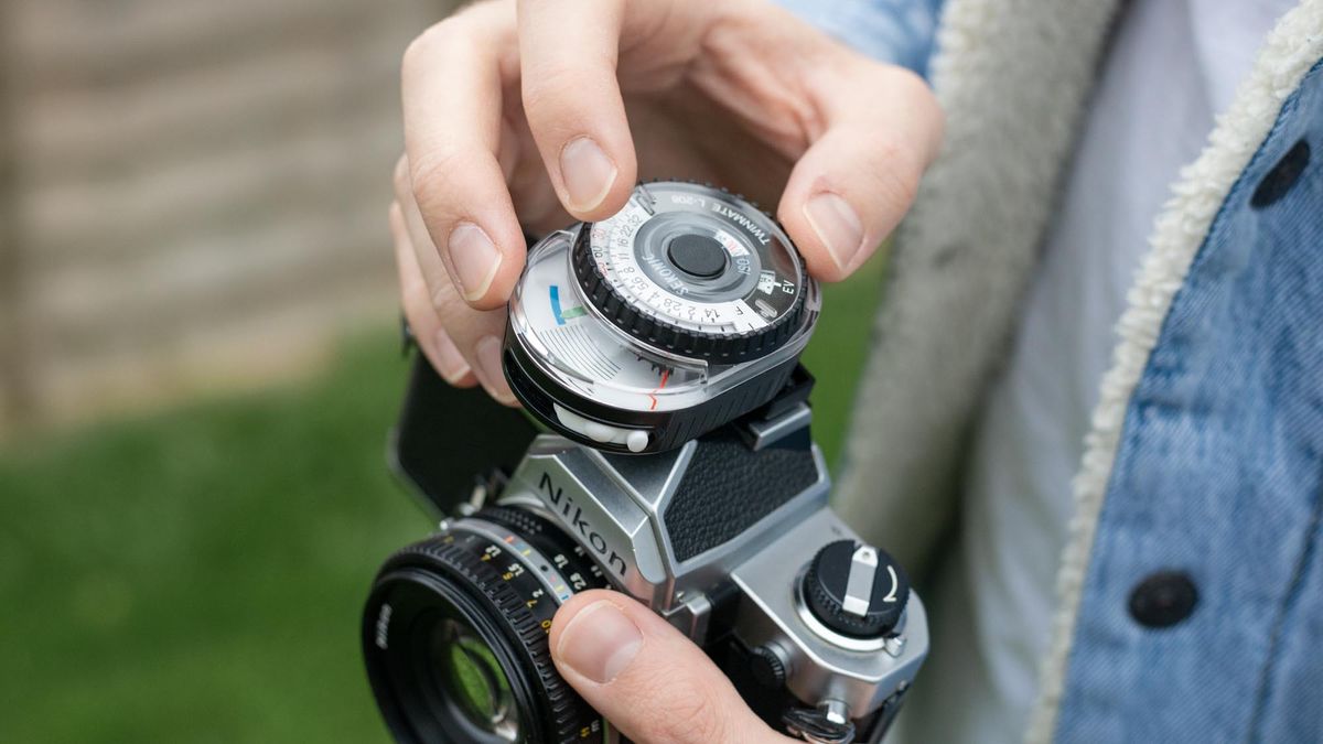 Man holding Nikon FM with Sekonic Twinmate L-208 mounted on hot shoe