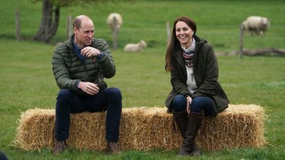 Catherine, Duchess of Cambridge and Prince William, Duke of Cambridge sit on hay balls during a royal visit to Manor Farm in Little Stainton, Durham on April 27, 2021 in Darlington, England
