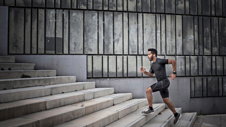 Man running up steps wearing a pair of the best workout shorts