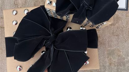 Close up image of studded Christmas presents with a large black velvet bow